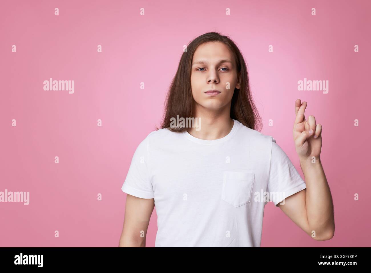 les jeunes hommes avec les doigts croisés croient en la bonne chance Banque D'Images