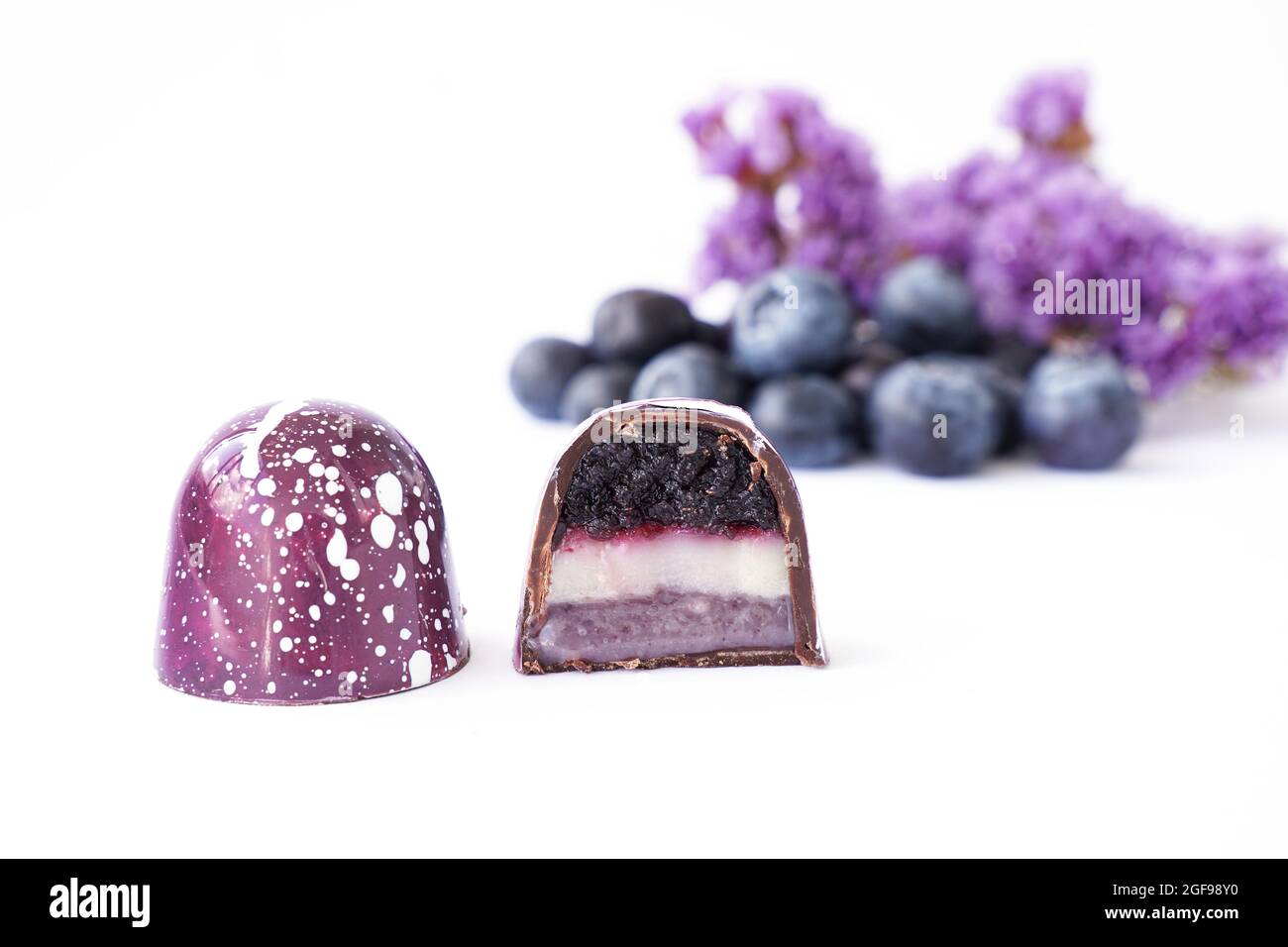 Bonbons au chocolat dans une coupe sur fond blanc. Saveur et goût de myrtille et de lavande. Ingrédients flous sur fond Banque D'Images