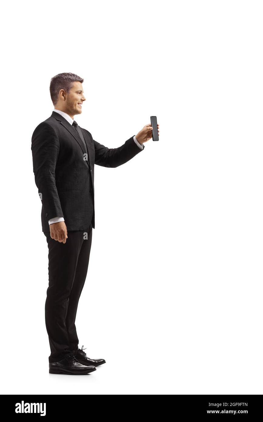 Vue en profil d'un homme d'affaires montrant un téléphone portable isolé sur fond blanc Banque D'Images