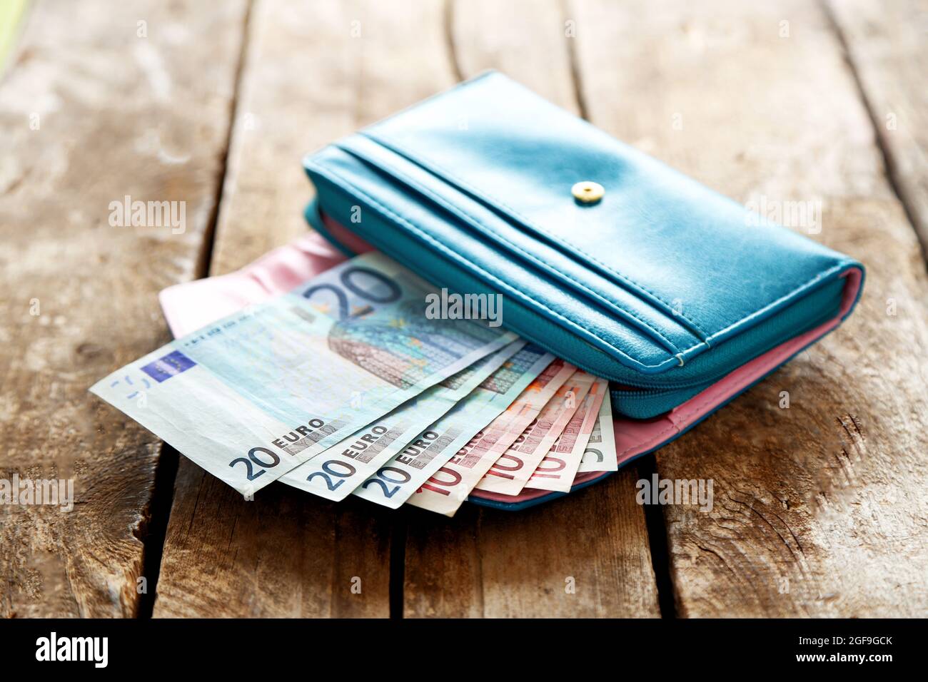 Porte-monnaie bleu ouvert avec billets en euros sur table en bois Photo  Stock - Alamy