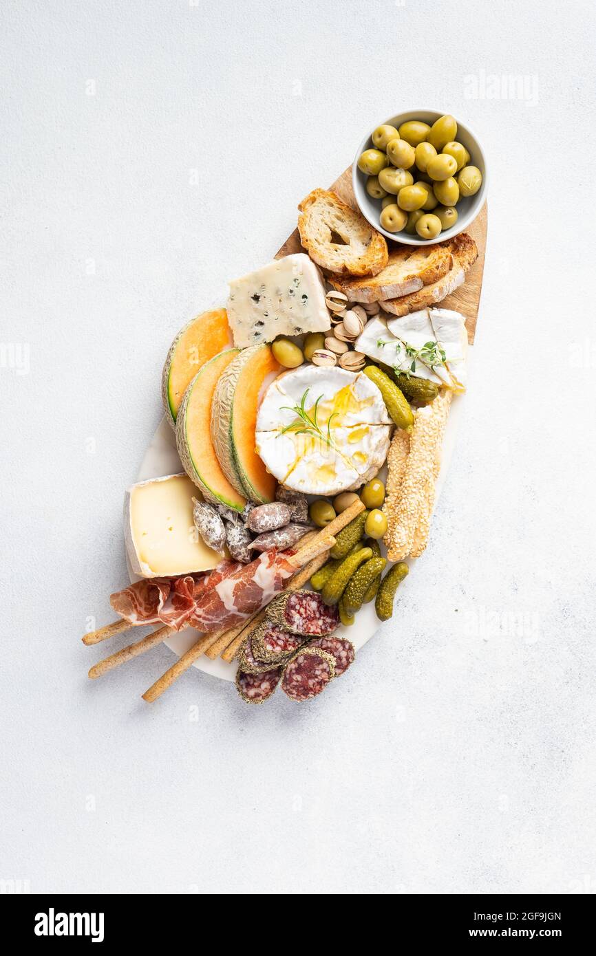 Plateau de fromages avec différents fromages, raisins, miel. Table de hors-d'œuvre avec en-cas d'antipasti. Vue de dessus, plan d'appartement Banque D'Images