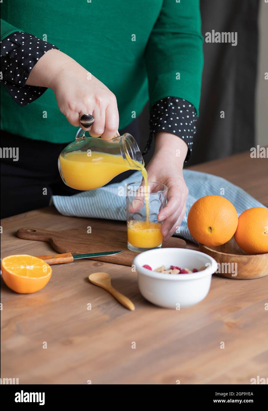Les mains servent le jus d'orange. Idée de petit déjeuner sain Banque D'Images