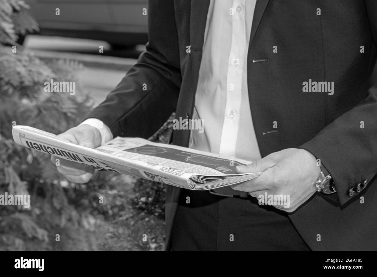 Vue partielle d'un homme ayant un journal dans les mains, en noir et blanc Banque D'Images