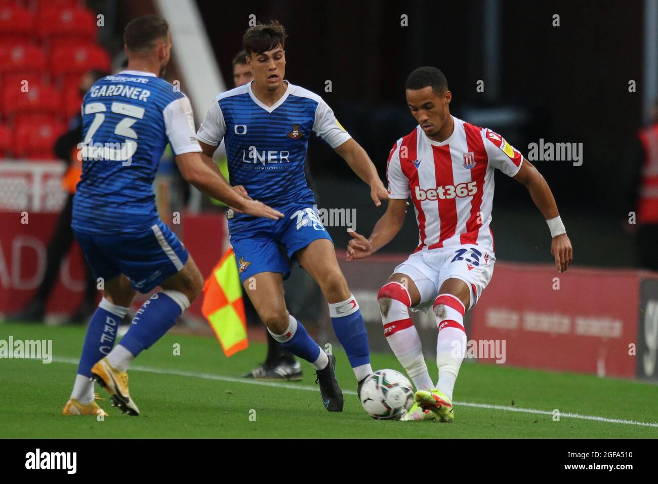 Stoke on Trent, Royaume-Uni. 24 août 2021. Thomas Ince, milieu de terrain de Stoke City (23), lutte pour le ballon avec le défenseur des Doncaster Rovers Branden Horton (28) et le milieu de terrain de Doncaster Rovers Dan Gardner (23) lors du deuxième match de la coupe EFL Carabao entre Stoke City et Doncaster Rovers au stade Bet365, Stoke-on-Trent, en Angleterre, le 24 août 2021. Photo de Jurek Biegus. Utilisation éditoriale uniquement, licence requise pour une utilisation commerciale. Aucune utilisation dans les Paris, les jeux ou les publications d'un seul club/ligue/joueur. Crédit : UK Sports pics Ltd/Alay Live News Banque D'Images