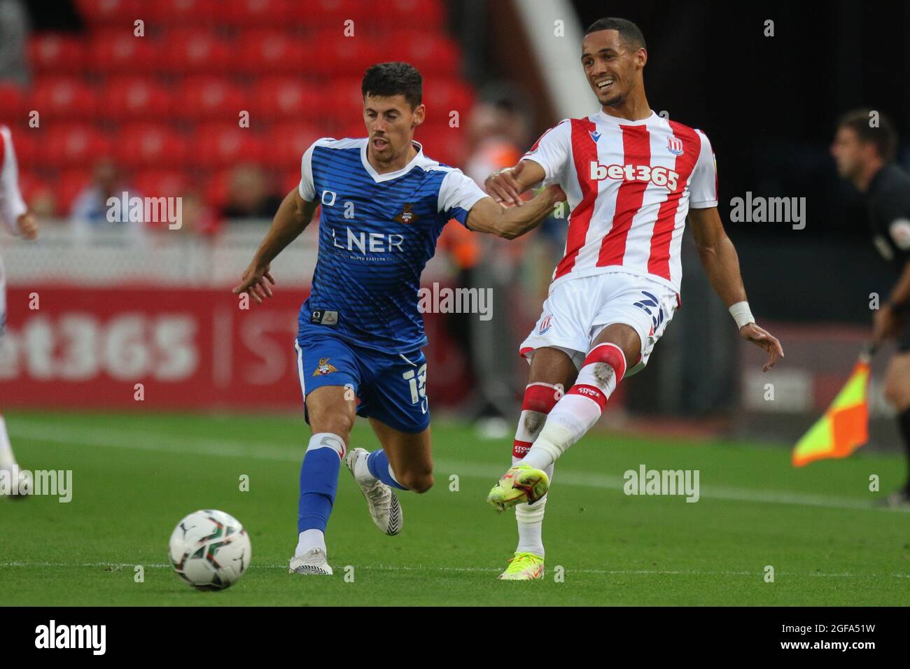 Stoke on Trent, Royaume-Uni. 24 août 2021. Le milieu de terrain de la ville de Stoke Thomas Ince (23) passe le ballon devant le milieu de terrain de Doncaster Rovers Ed Williams (18) lors du deuxième match de la coupe EFL Carabao entre Stoke City et Doncaster Rovers au stade Bet365, Stoke-on-Trent, en Angleterre, le 24 août 2021. Photo de Jurek Biegus. Utilisation éditoriale uniquement, licence requise pour une utilisation commerciale. Aucune utilisation dans les Paris, les jeux ou les publications d'un seul club/ligue/joueur. Crédit : UK Sports pics Ltd/Alay Live News Banque D'Images