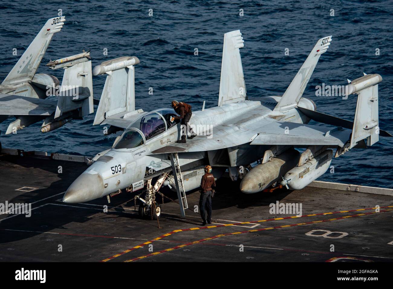 Mer d'Arabie, États-Unis. 24 août 2021. Les marins de la Marine américaine nettoient la verrière d'un avion d'attaque électronique EA-18G Growler, attaché aux Shadowhawks de l'escadron d'attaque électronique 141, avant de prendre le pont de vol du porte-avions USS Ronald Reagan le 24 août 2021 dans la mer d'Arabie. Credit: Planetpix/Alamy Live News Banque D'Images