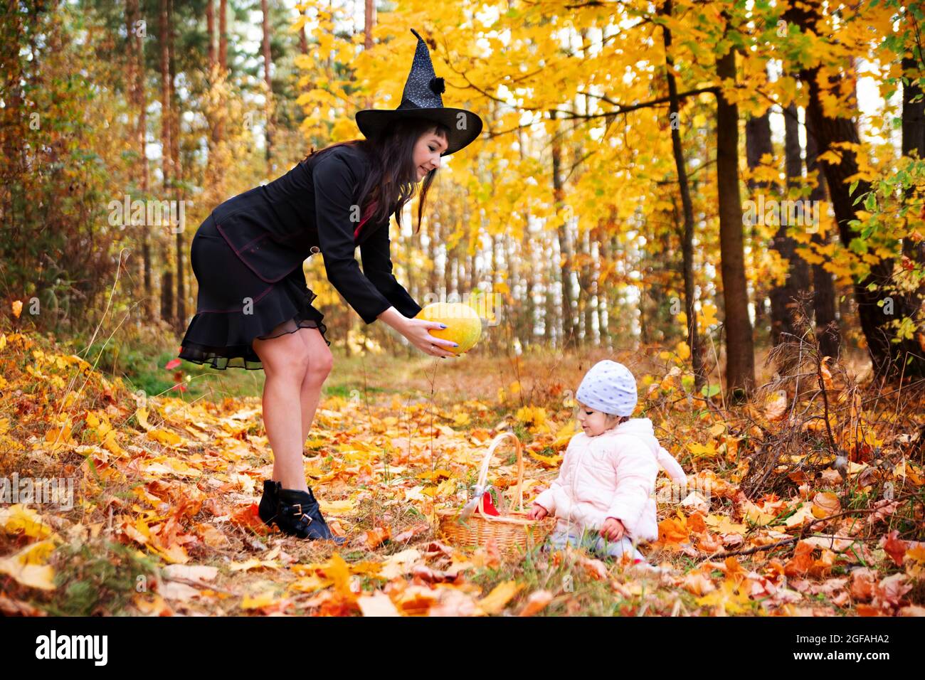 sorcière noire avec petit lapin dans la forêt d'automne. fête d'halloween, fête de costume Banque D'Images