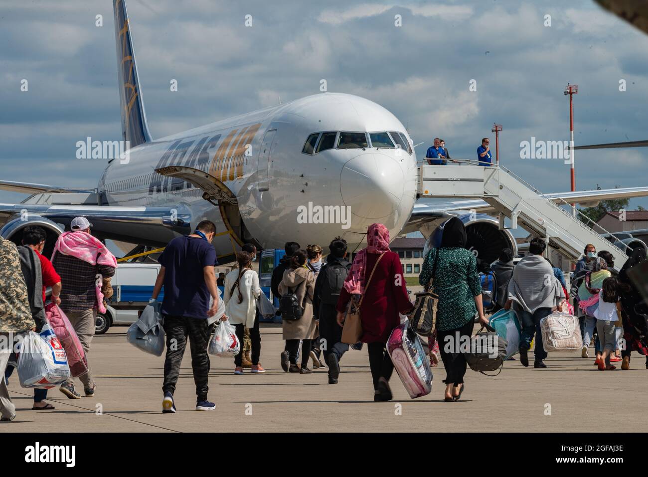 Ramstein Miesenbach, Allemagne. 24 août 2021. Les réfugiés afghans embarquaient à bord d'un avion commercial Atlas Air pour être transférés aux États-Unis après l'évacuation de Kaboul à la base aérienne de Ramstein le 24 août 2021 à Ramstein-Miesenbach, en Allemagne. Le Pentagone a appelé 18 avions civils de United Airlines, American Airlines, Delta Air, Atlas Air et Hawaiian Airlines en vertu de la loi sur la flotte aérienne de la Réserve civile pour aider à transférer les évacués dans le cadre de l'opération alliés refuge. Credit: Planetpix/Alamy Live News Banque D'Images