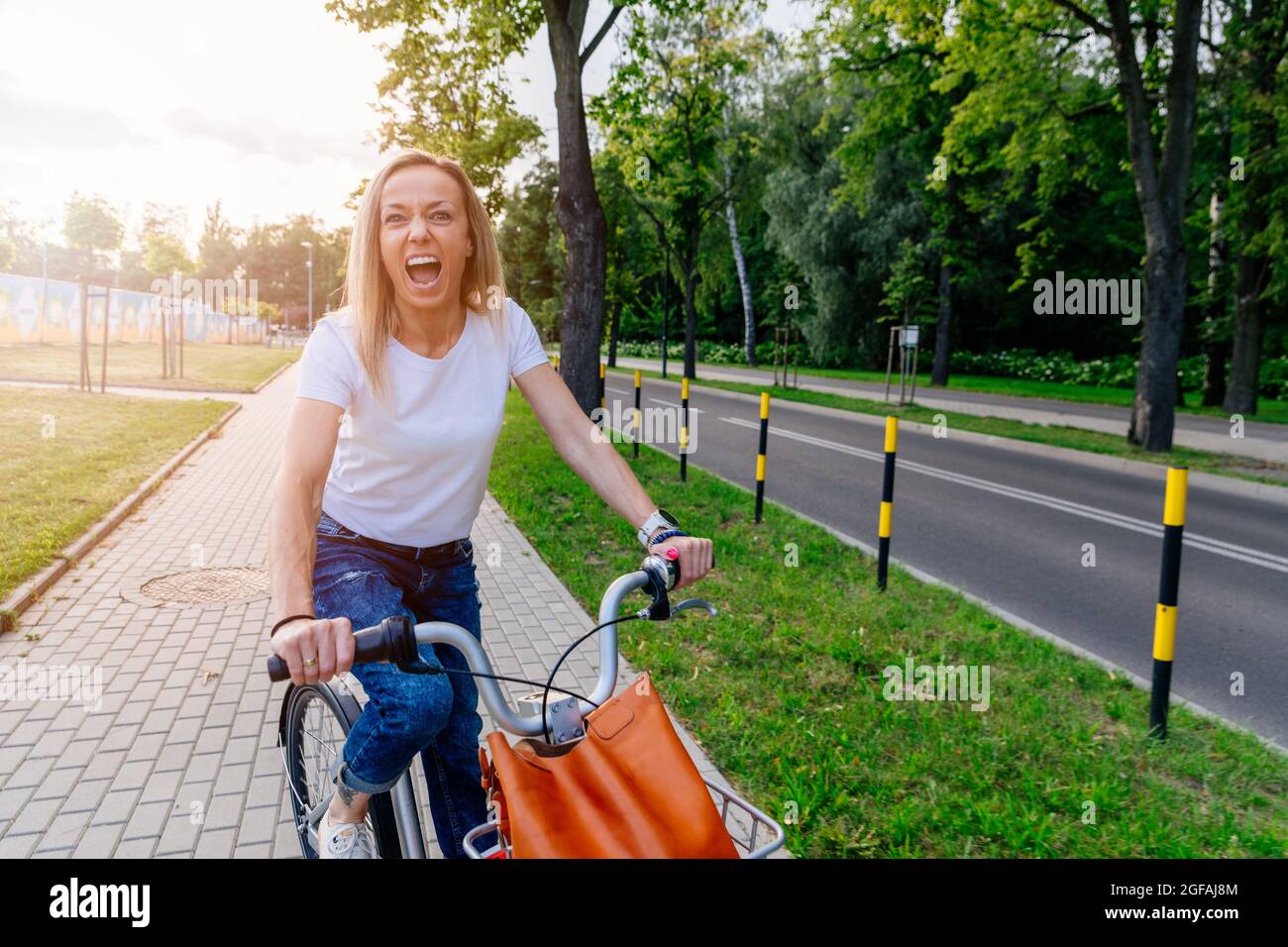 Une femme joyeuse se promener en vélo dans la ville. Banque D'Images