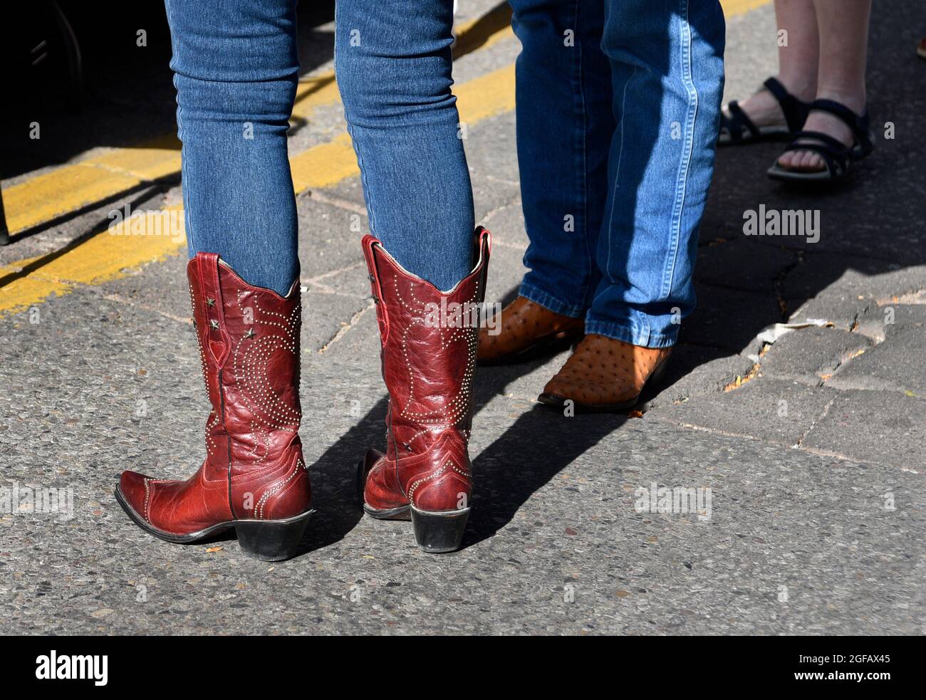 Un couple bien habillé portant une tenue de l'Ouest américain visite un spectacle d'art en plein air à Santa Fe, Nouveau-Mexique. Banque D'Images