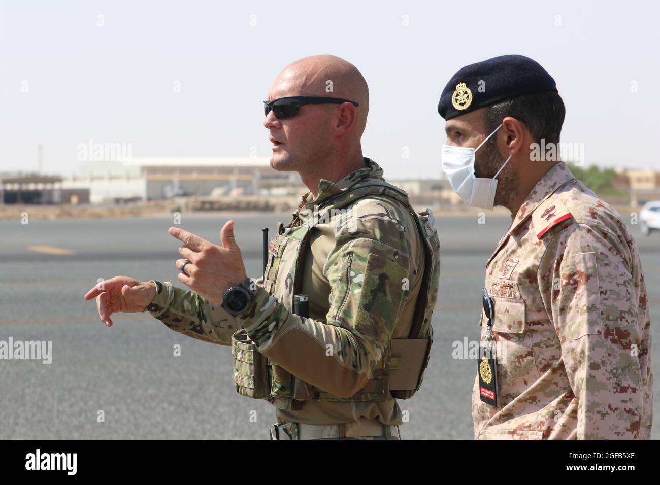 Un officier de la Force aérienne américaine affecté à la 386e Escadre expéditionnaire aérienne et un officier de l’armée du Koweït ont une discussion avant le premier vol C-17 transportant des Afghans en sécurité au Koweït à la base aérienne Ali Al Salem, au Koweït. Bien que l'opération soit dirigée par le Département d'État, le ministère de la Défense a été chargé d'aider à fournir le transport, la sécurité, la logistique et le soutien médical aux détenteurs de visas d'immigration spéciaux à divers endroits, où ils devront suivre un processus rigoureux de paperasserie avant d'arriver à leur destination finale. À ce jour, le ministère de la Défense nationale Banque D'Images