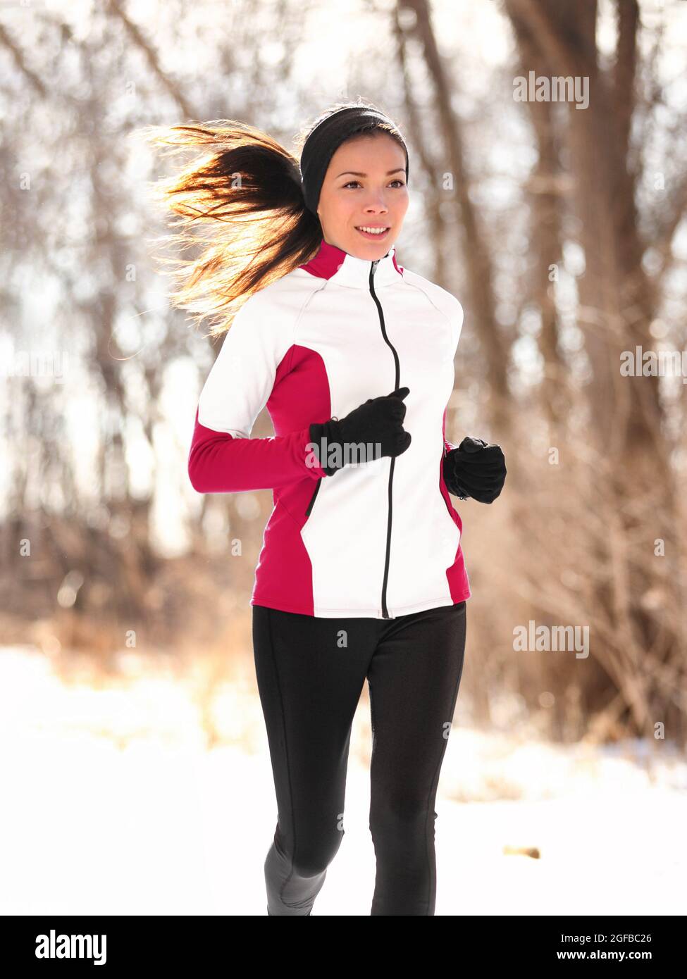 Hiver femme coureur jogging à l'extérieur dans la forêt Banque D'Images