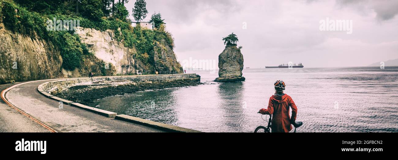 Femme de vélo de Vancouver sur une piste cyclable au parc Stanley célèbre siwash rock, activité touristique en Colombie-Britannique, Canada. Panorama de bannière. Cycliste sur route Banque D'Images