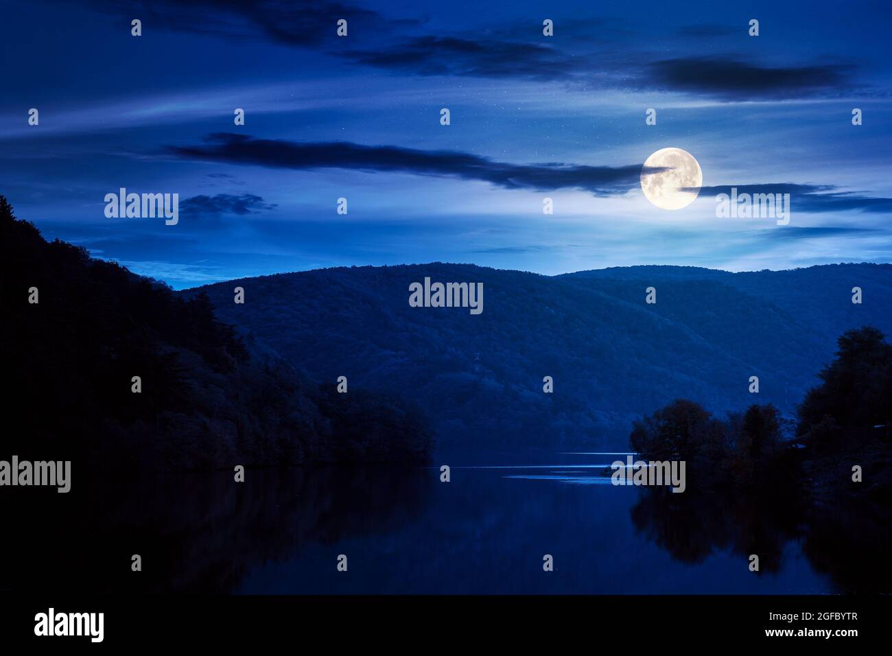 magnifique paysage avec lac la nuit. nuages sombres se reflétant sur la surface de l'eau. magnifique paysage automnal dans les montagnes en pleine lumière de lune Banque D'Images