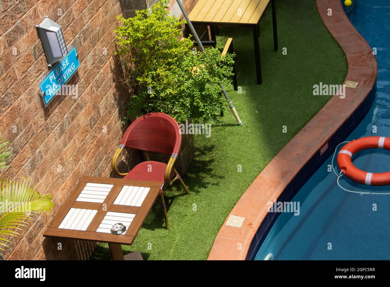 Petite piscine dans une résidence privée de luxe, avec tables et chaises, plantes décoratives et anneaux flottants Banque D'Images