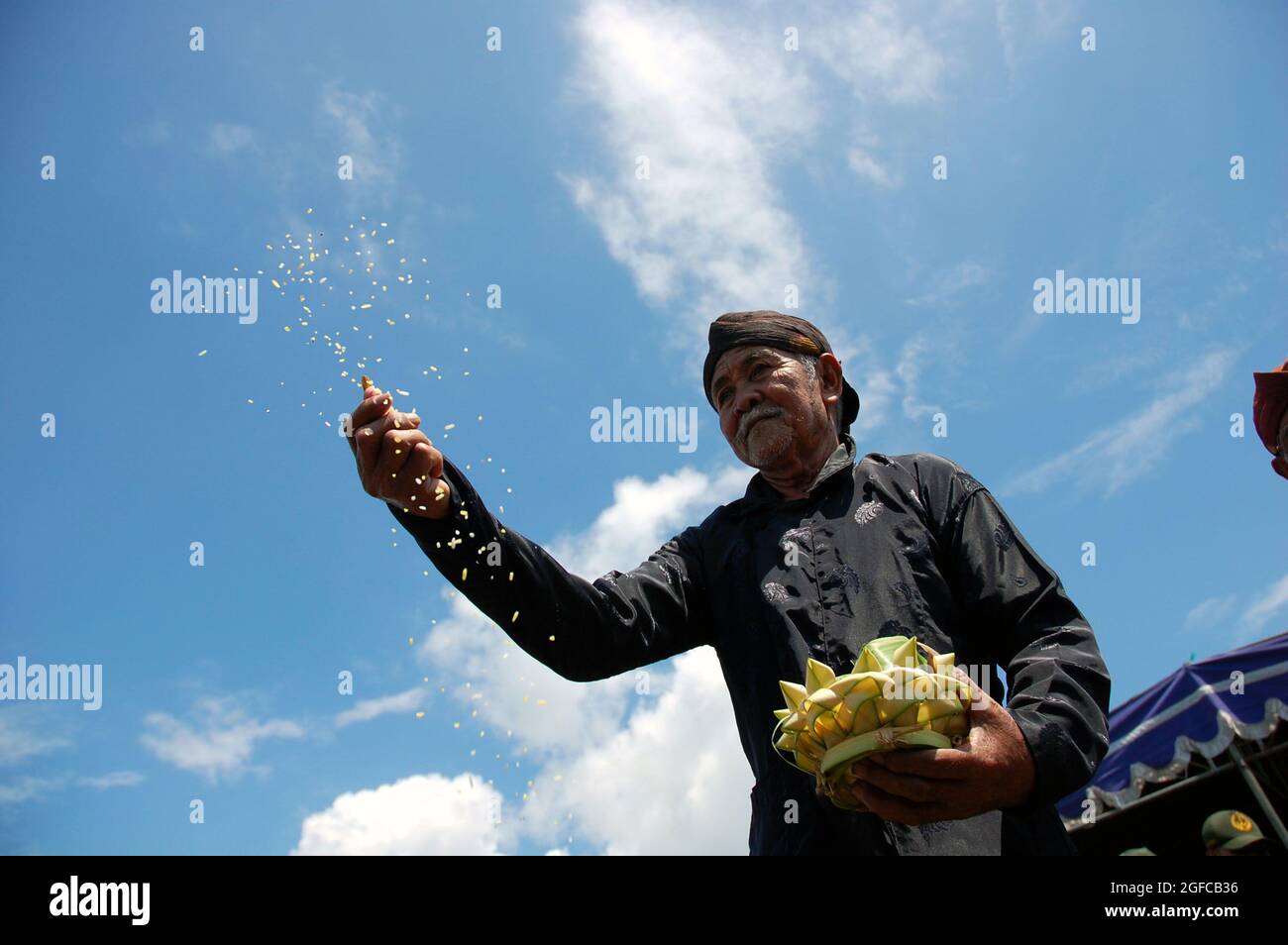 Jetez la fleur comme un symbole de bénir et d'espoir. Le pêcheur espère qu'au cours du mois prochain il aura de la chance, de la sécurité et beaucoup de poissons. Bantul, Yogyakarta, Indonésie. 2 février 2006. Une fois par an, les pêcheurs de Samas Beach, Bantul, Yogyakarta envoient des offrandes rituelles au NYI Roro Kidul (Reine de la mer du Sud), une déité de la mythologie indonésienne. Ils croient que la Déesse leur accordera une année de bénédiction et de chance. Janvier est un mois difficile pour les pêcheurs à cause de la marée haute en mer du Sud, mais leur foi et leur croyance sur la Déesse leur donnent de l'espoir. Banque D'Images