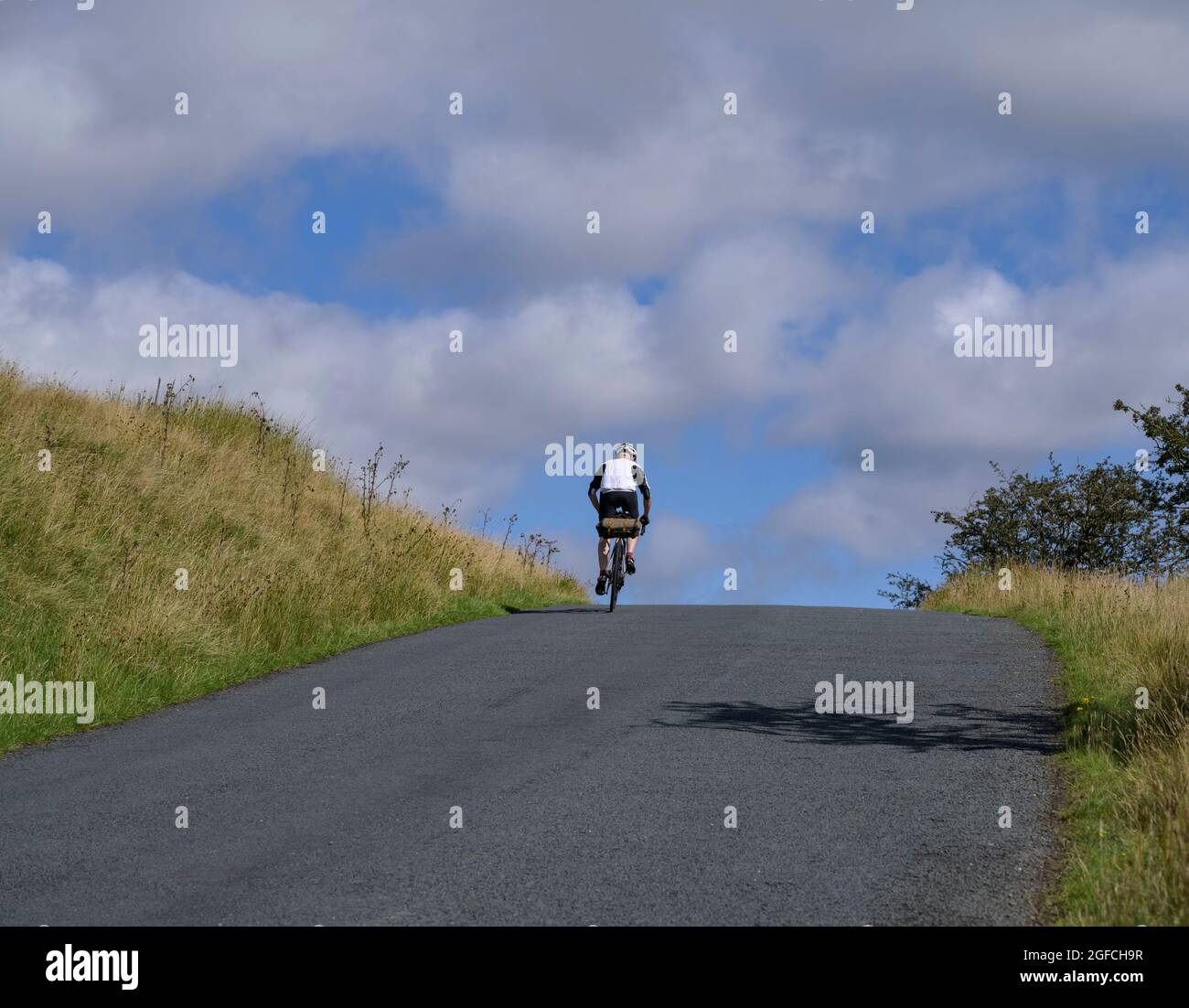 Cycliste mature, homme, qui se déchire sur une colline, au creux de Bowland, Lancashire, Royaume-Uni. Banque D'Images