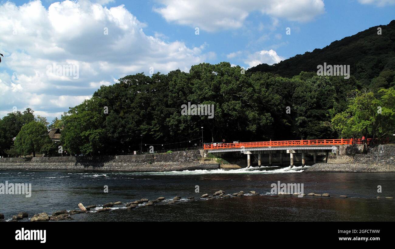 Pont rouge traversant une rivière peu profonde dans un environnement très vert au Japon. Banque D'Images