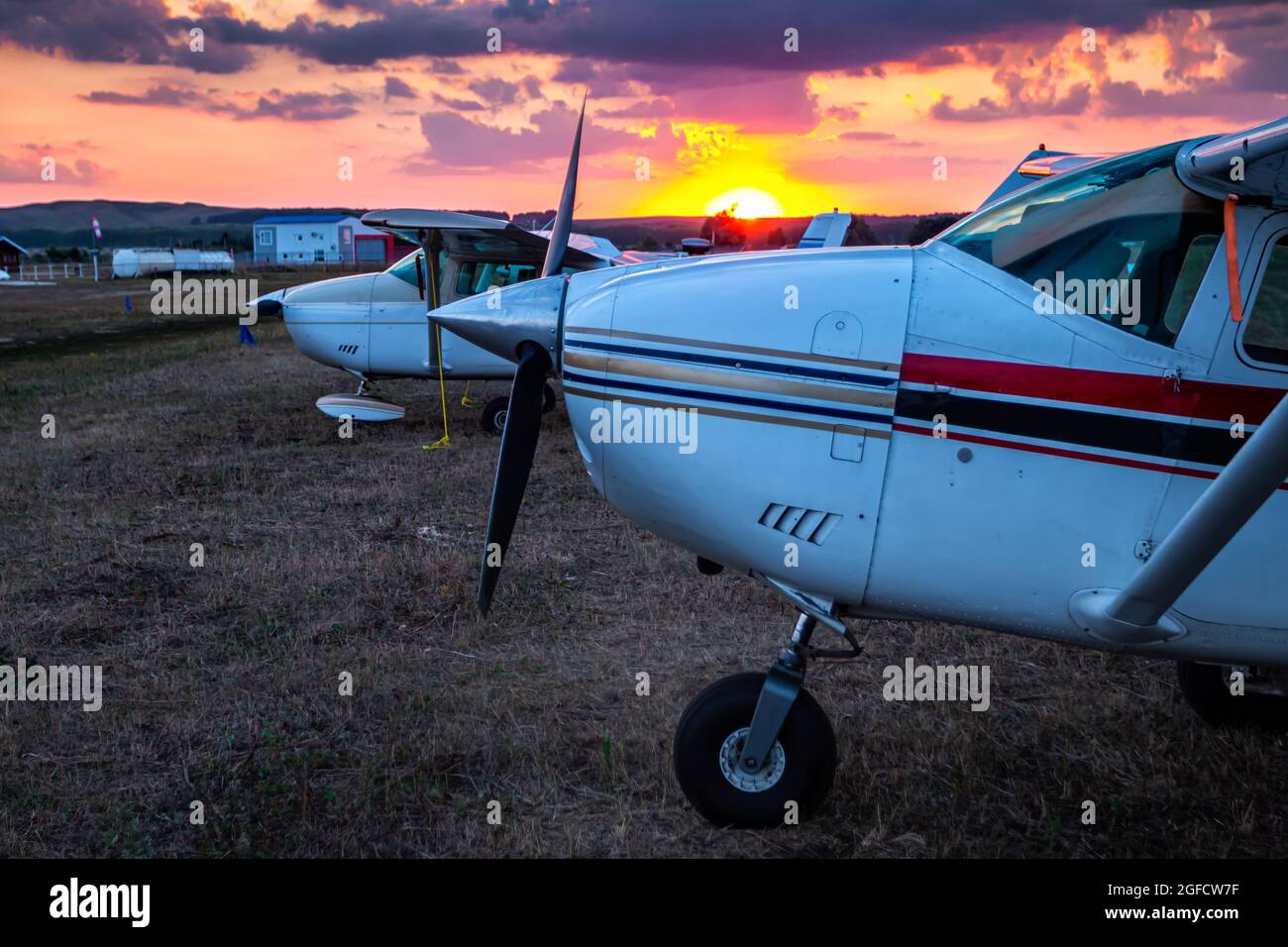 Gros plan petits avions privés garés à l'aérodrome au coucher du soleil pittoresque Banque D'Images
