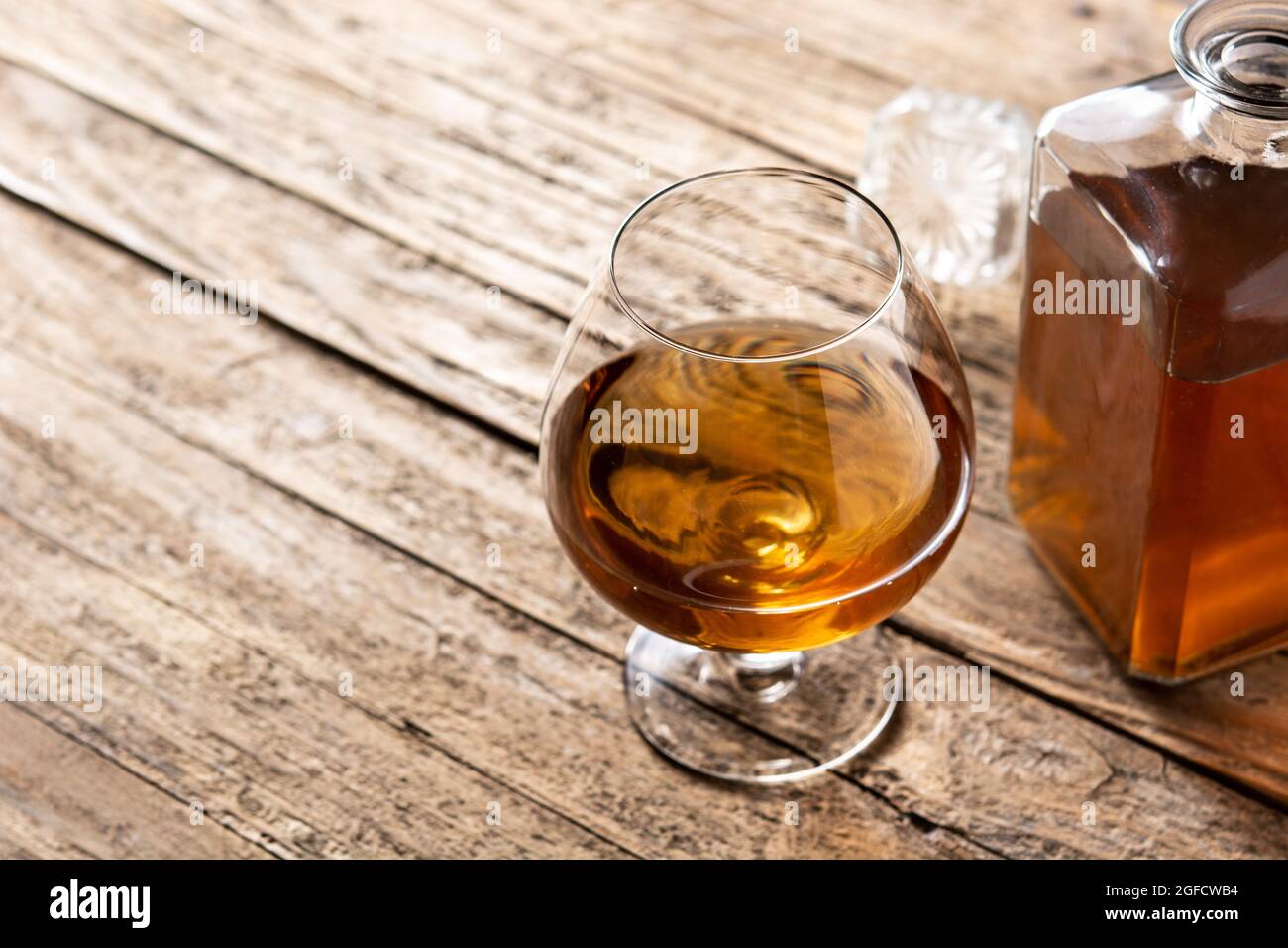 Boisson au Cognac ou au whisky sur table rustique en bois et fond noir. Banque D'Images