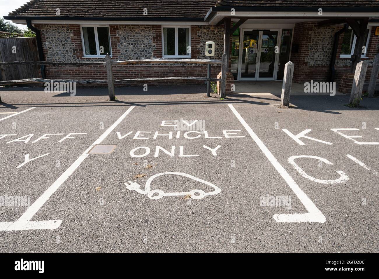 Place de stationnement marquée véhicule électrique uniquement dans un parking à l'hôtel de village, Royaume-Uni Banque D'Images