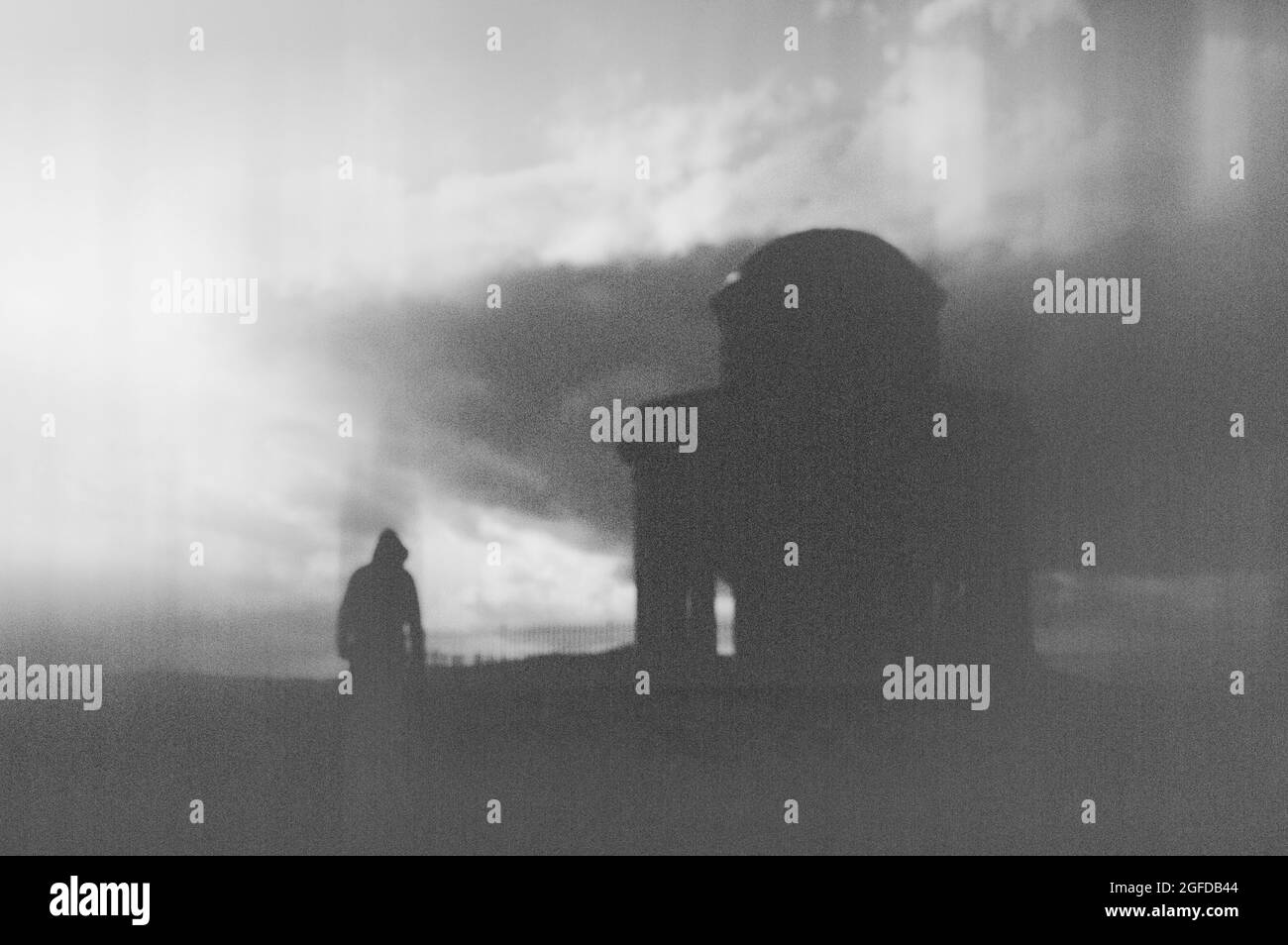 Un concept de fantaisie sombre . D'une figure solitaire perdue à capuchon, debout à côté d'un vieux bâtiment historique. Avec une modification floue et abstraite. Banque D'Images