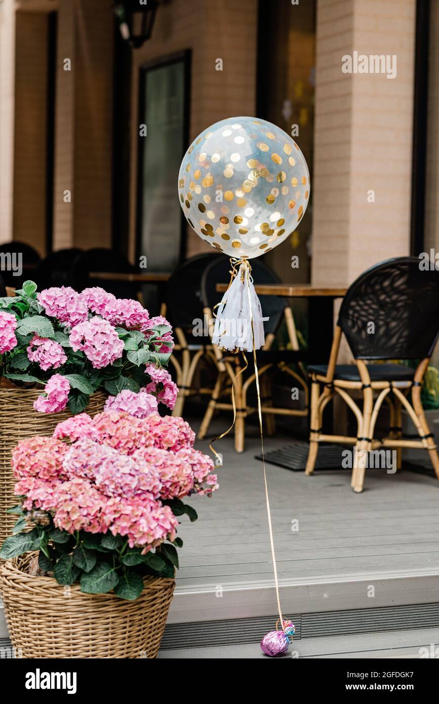 Ballon festif avec confettis dorés dans les pots de fleurs d'hortensias du  restaurant. Mise au point sélective douce Photo Stock - Alamy