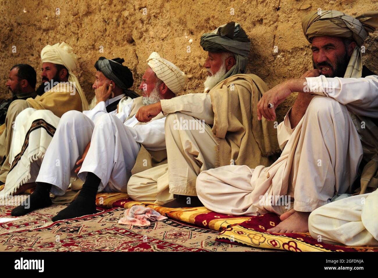 Les anciens du village siègent comme l'ancien commandant taliban parle pendant la shura Mars 17, dans le village de Sorkh-AB, dans le district de Muhammed Aga, province de Logar, Afghanistan. Banque D'Images