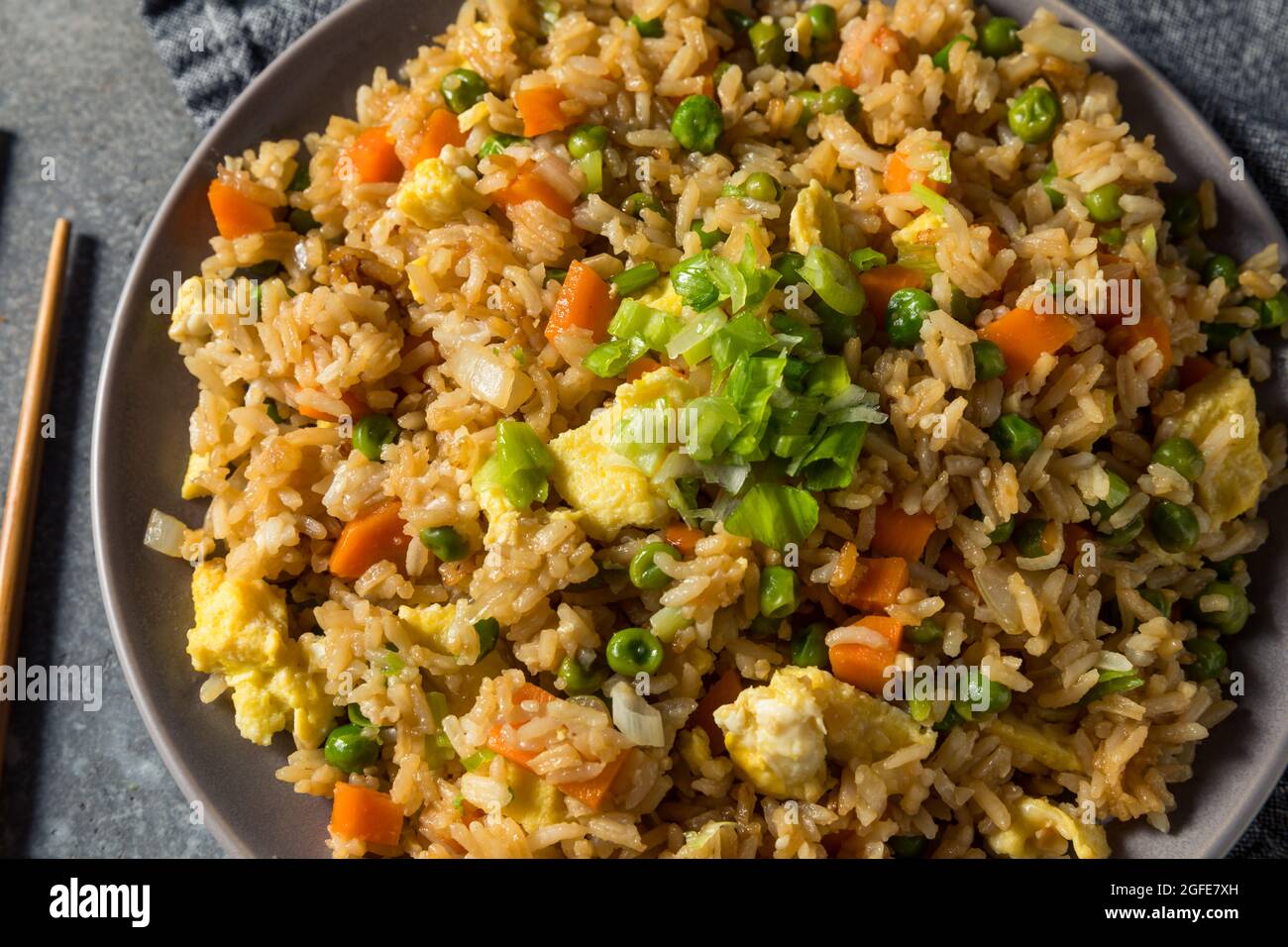 Riz frit chinois maison avec œufs, carottes et petits pois Banque D'Images