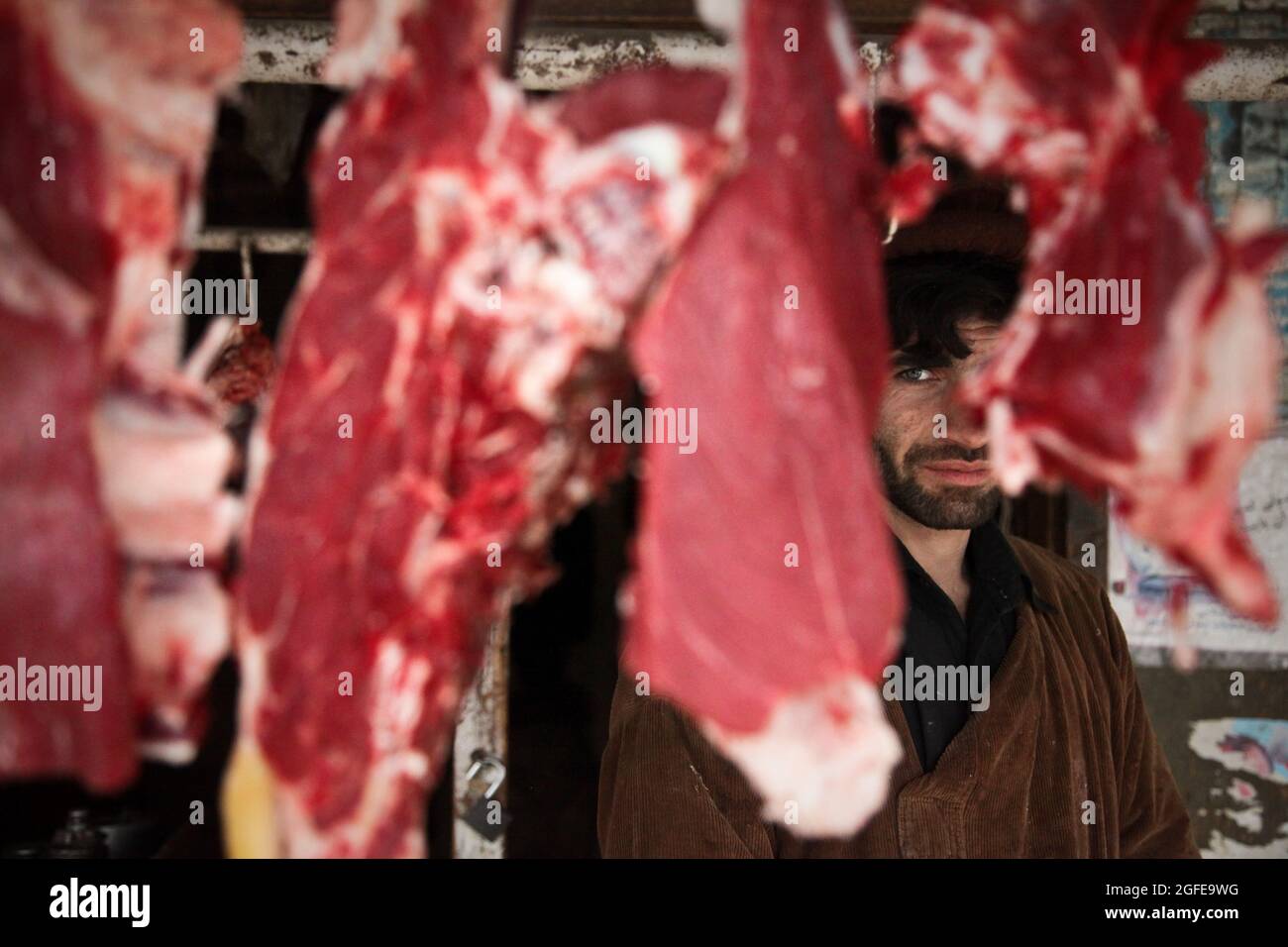 Un boucher afghan se tient derrière ses produits au Bazar d'Anaba, dans la province de Panjshir, en Afghanistan, le 02 janvier 2010. Les bouchers afghans pendent habituellement la viande à l'extérieur de leurs magasins et les présentent à leurs clients. (É.-U. Photo de l'armée par le Sgt. Teddy Wade/relâché) Banque D'Images