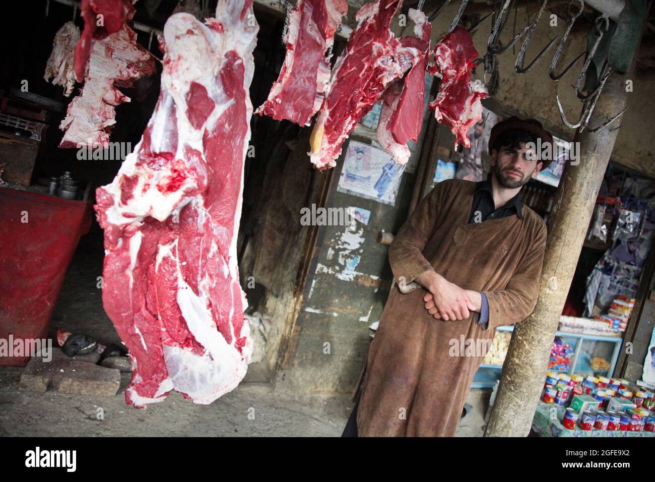 Un boucher afghan se tient à côté de ses produits au Bazar d'Anaba, dans la province de Panjshir, en Afghanistan, le 02 janvier 2010. Les bouchers afghans pendent habituellement la viande à l'extérieur de leurs magasins et les présentent à leurs clients. (É.-U. Photo de l'armée par le Sgt. Teddy Wade/relâché) Banque D'Images