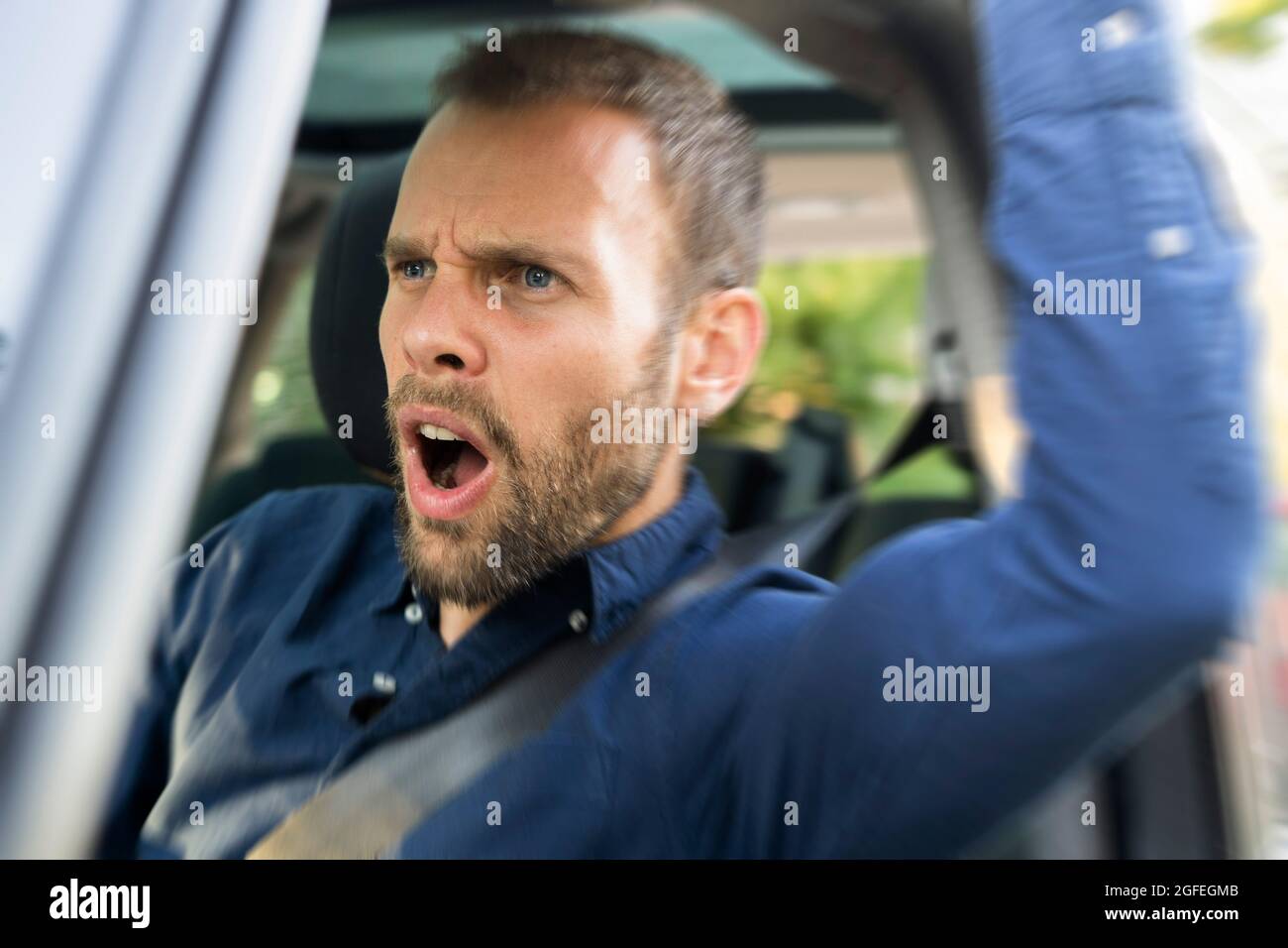 Jeune homme frustré conduisant une voiture Banque D'Images