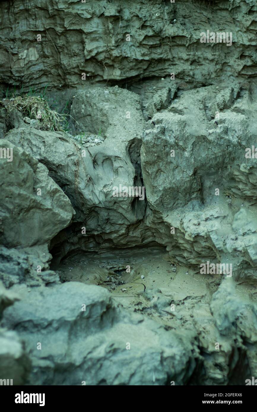 Des trous profonds ont été faits dans les rives de la rivière après que l'eau de pluie ait coulé Banque D'Images