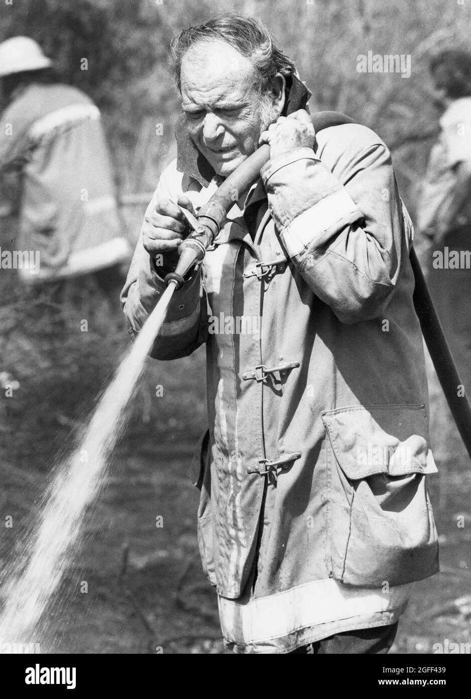 Austin Texas USA, vers 1986: Pompier volontaire senior aidant à mettre un feu d'herbe. ©Bob Daemmrich Banque D'Images
