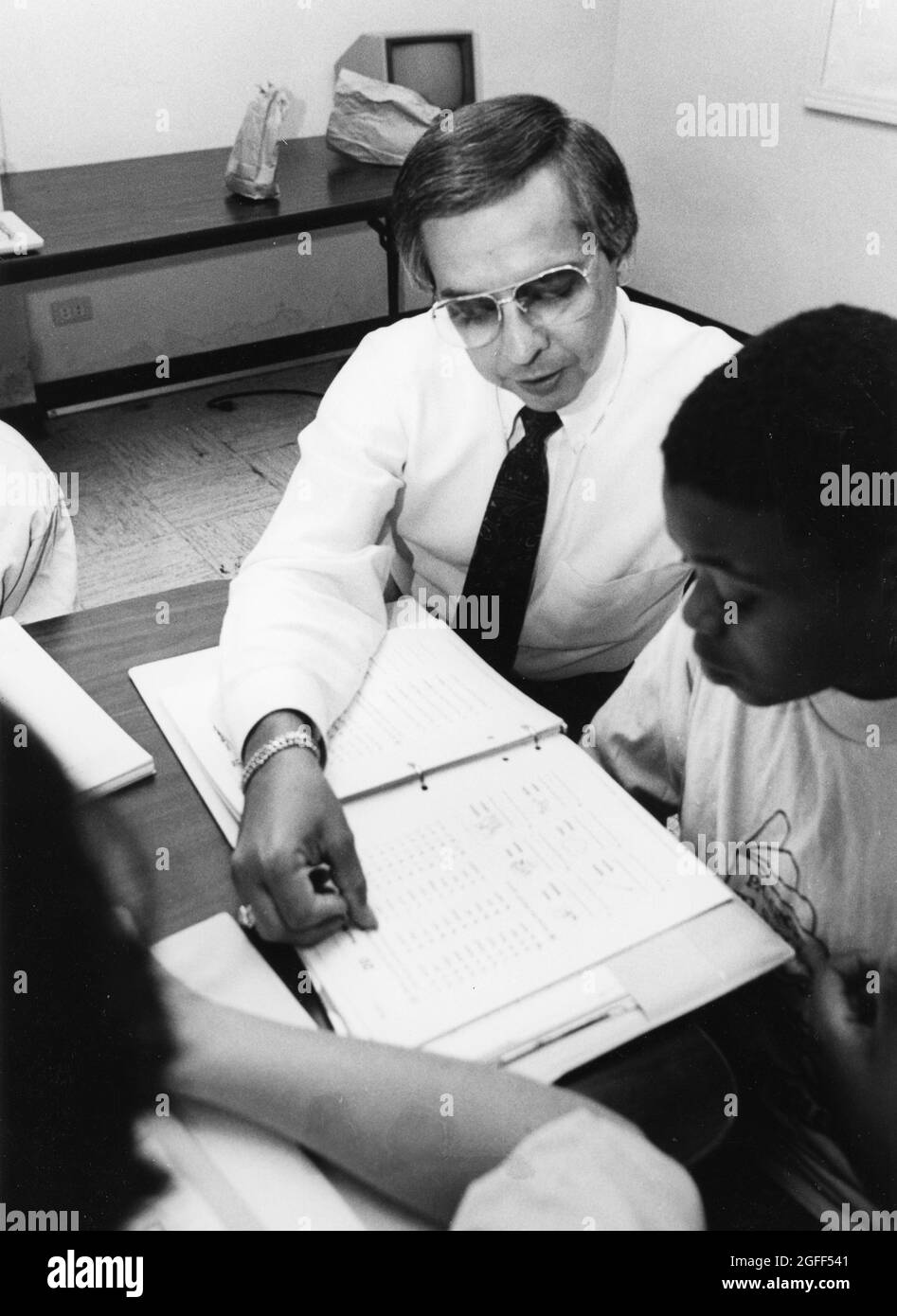 Austin Texas USA, vers 1989: Le volontaire du Club des garçons, Tony Pena, aide un étudiant de secondaire de sexe masculin noir à améliorer ses compétences en lecture. M. XRE-0200 Banque D'Images Austin Texas USA, vers 1989: Le volontaire du Club des garçons, Tony Pena, aide un étudiant de secondaire de sexe masculin noir à améliorer ses compétences en lecture. M. XRE-0200 Banque D'Images