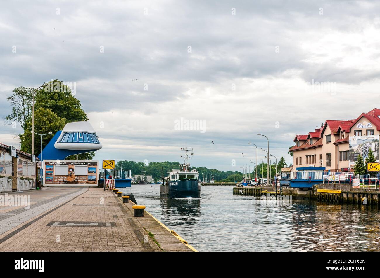 Darłówko, Pologne 08 août 2021 Rivière Wieprza, pont coulissant pour piétons, vue sur le pont étendu et un bateau de pêche passant, pour éditorial Banque D'Images