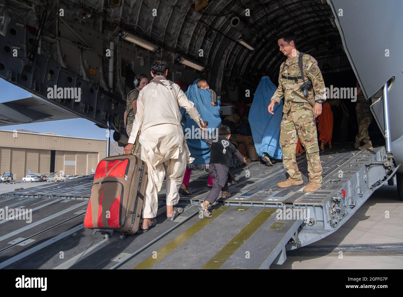 Kaboul, Afghanistan. 24 août 2021. Un aviateur de la Force aérienne des États-Unis avec le 816e Escadron de transport aérien expéditionnaire aide les réfugiés afghans à monter à bord d'un avion C-17 Globemaster III pour l'évacuation de l'aéroport international Hamid Karzaï pendant le refuge de l'opération alliés, le 24 août 2021 à Kaboul, en Afghanistan. Credit: Planetpix/Alamy Live News Banque D'Images