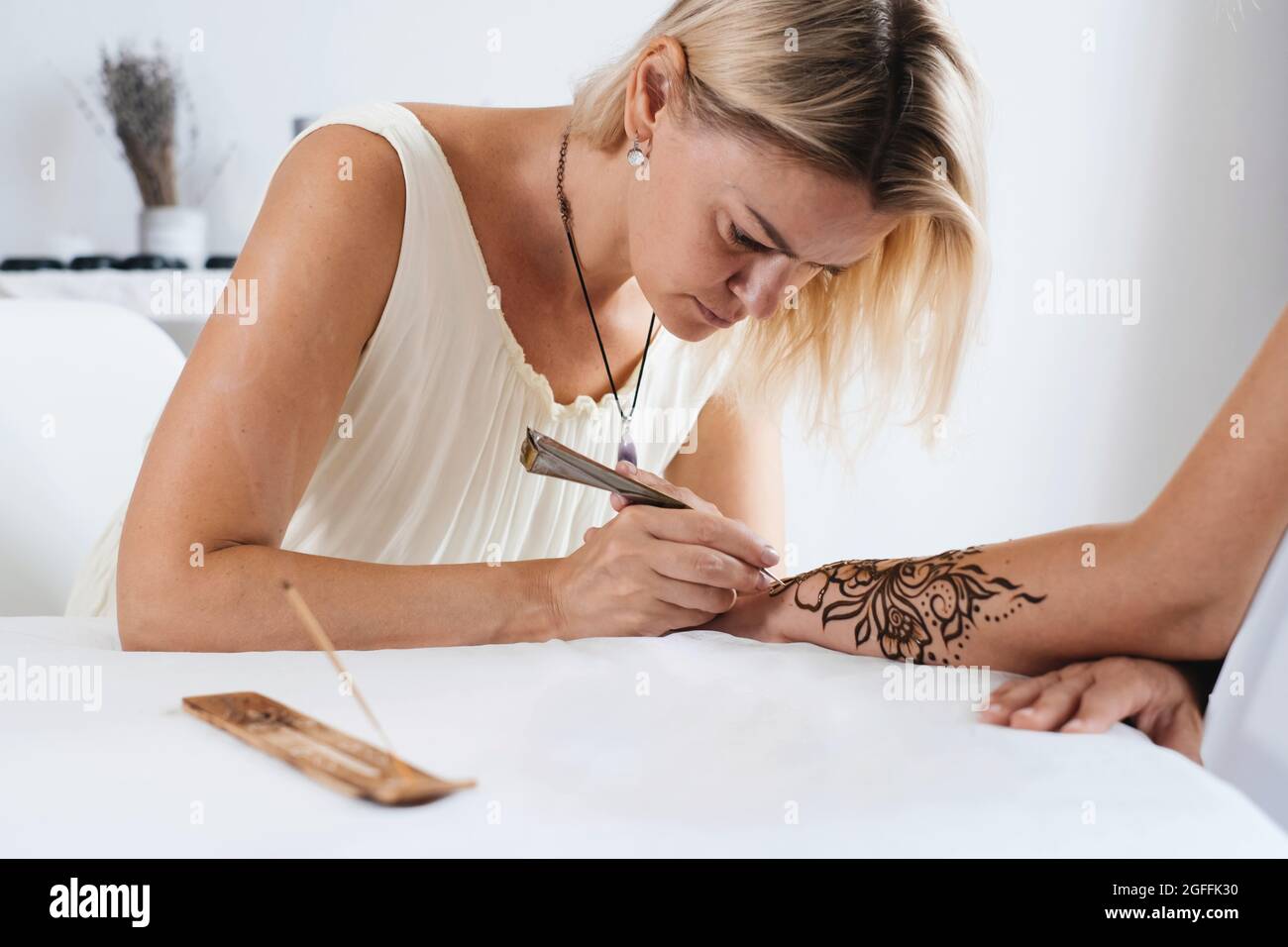 Artiste appliquant le tatouage au henné sur les mains des femmes. Le mehndi est un art décoratif indien traditionnel, à la main avec du mehendi floral. Dessin de beauté pour les mariages et Banque D'Images