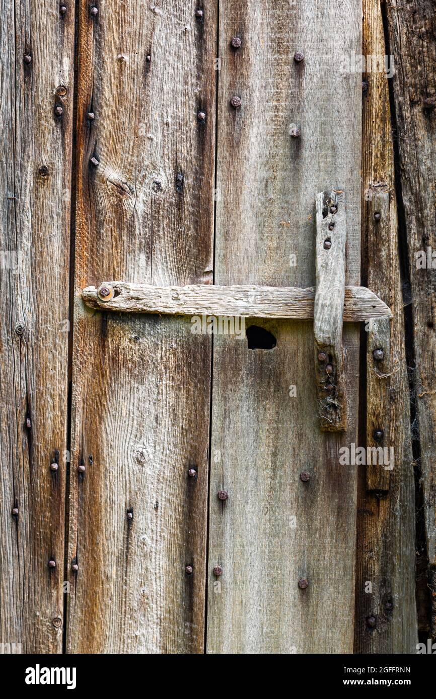 Ancienne porte stable et résistante aux intempéries avec verrou et poignée en bois Banque D'Images