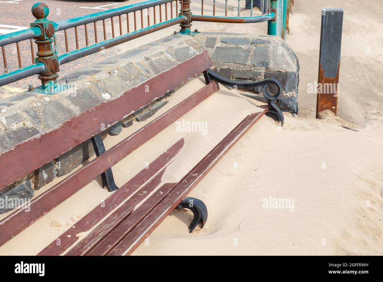 Bancs publics enterrés dans du sable dérivant à vent Banque D'Images
