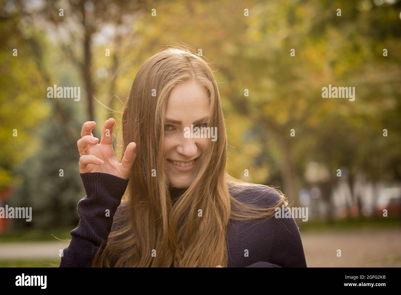 Belle jeune femme sur fond d'arbres d'automne. Concept d'émotion. Promenez-vous dans le parc d'automne. Banque D'Images