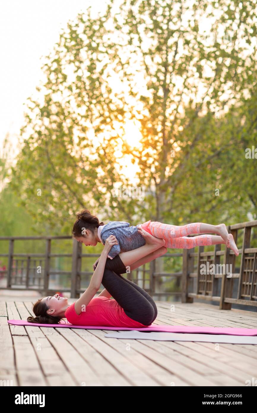 Bonne mère et fille faisant du yoga à l'extérieur Banque D'Images