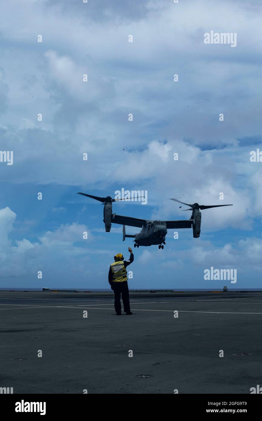 Un marin de la marine britannique dirige un MV-22 Osprey lors d'exercices de toucher-et-Go à bord du HMS Queen Elizabeth dans la mer des Philippines, le 21 août 2021. La formation croisée avec les alliés et les partenaires améliore notre capacité à travailler ensemble et à rester tactiquement compétent. Le 31e MEU opère à bord des navires du groupe de grève expéditionnaire américain dans la zone d'opérations de la 7e flotte afin d'améliorer l'interopérabilité avec les alliés et les partenaires et de servir de force de réaction prête à défendre la paix et la stabilité dans la région Indo-Pacifique. (É.-U. Photo du corps marin par Cpl. Alexandria Nowell) Banque D'Images