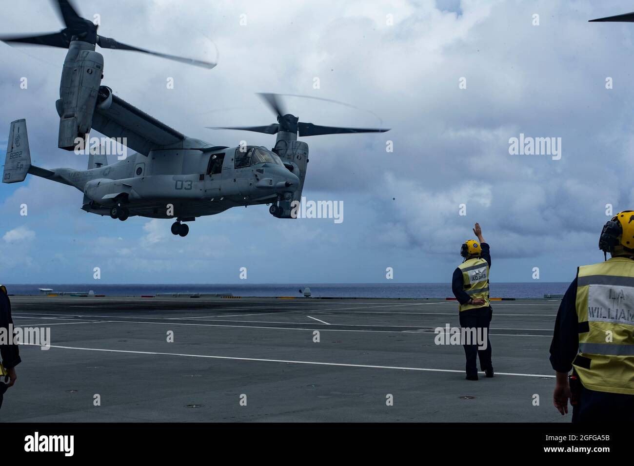 Un marin de la marine britannique dirige un MV-22 Osprey lors d'exercices de toucher-et-Go à bord du HMS Queen Elizabeth dans la mer des Philippines, le 21 août 2021. La formation croisée avec les alliés et les partenaires améliore notre capacité à travailler ensemble et à rester tactiquement compétent. Le 31e MEU opère à bord des navires du groupe de grève expéditionnaire américain dans la zone d'opérations de la 7e flotte afin d'améliorer l'interopérabilité avec les alliés et les partenaires et de servir de force de réaction prête à défendre la paix et la stabilité dans la région Indo-Pacifique. (É.-U. Photo du corps marin par Cpl. Alexandria Nowell) Banque D'Images