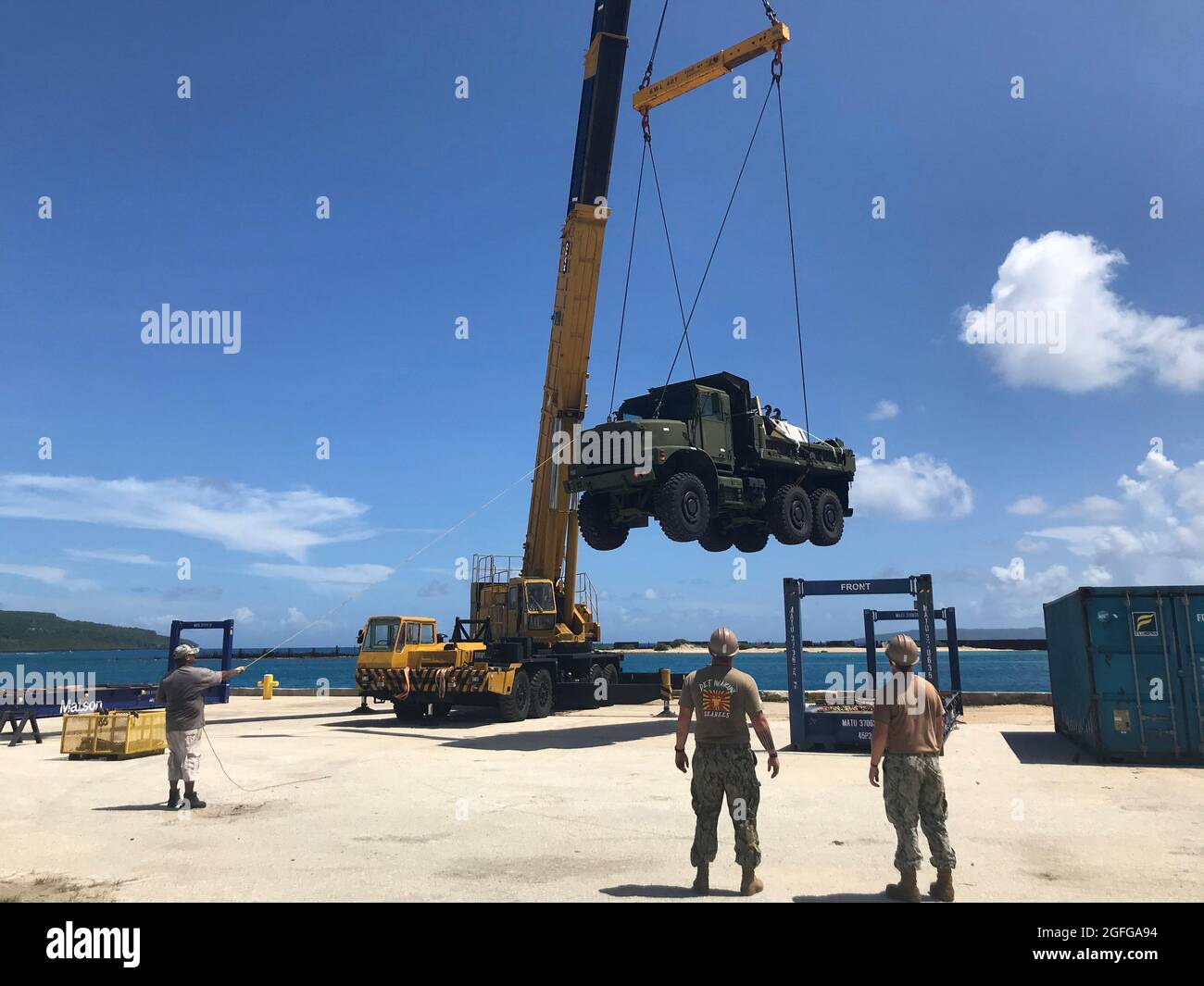 210810-N-OU239-1004 TINIAN, Îles Mariannes du Nord (août 10, 2021) opérateur d'équipement Constructionman Mekai Cross, affecté au Bataillon de construction mobile navale (NMCB) 5, guide l'opérateur d'équipement de 3e classe Baloy, affecté au Bataillon de construction amphibie 1, tout en chargeant un petit tracteur-remorque à Tinian Harbour pour soutenir l'exercice Freedom Banner. Les Seabees de la Marine américaine affectés au NMCB-5 sont déployés dans la zone d'opérations de la 7e flotte des États-Unis, appuyant une Indo-Pacific libre et ouverte, renforçant un réseau d'alliés et de partenaires, et fournissant un soutien général en ingénierie et en civil à Banque D'Images