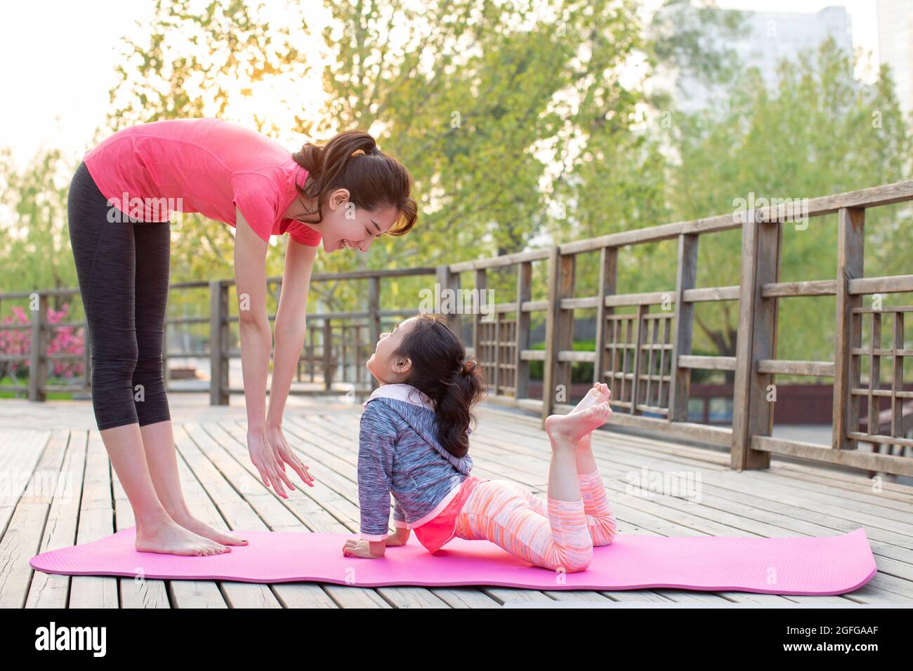 Bonne mère et fille faisant du yoga à l'extérieur Banque D'Images