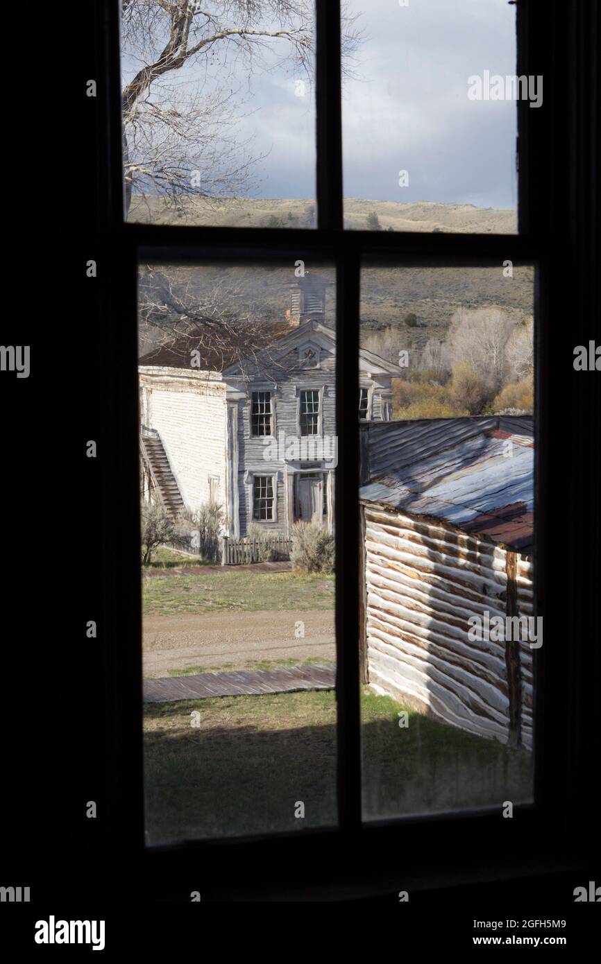 Vue sur le temple maçonnique/l'école depuis la fenêtre à l'étage de l'hôtel Meade, parc national de Bannack, MT. Banque D'Images