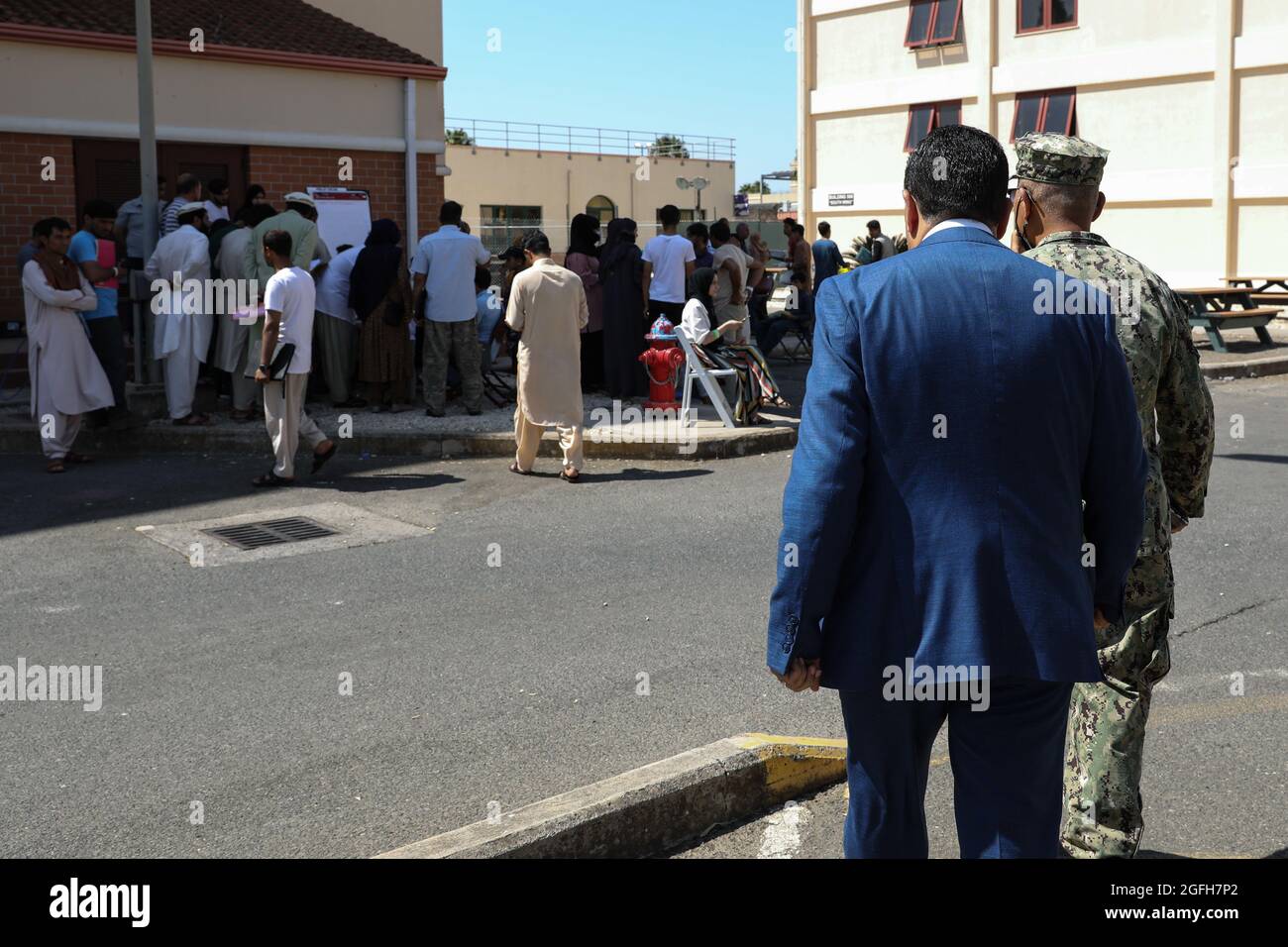 STATION NAVALE AÉRIENNE DE SIGONELLA, Italie (août 24, 2021) Kheit Abdelhafic, un imam de la communauté locale, à droite, visite les évacués séjournant à la base aérienne navale de Sigonella, le 24 août 2021. NAS Sigonella appuie actuellement la mission du ministère de la Défense visant à faciliter le départ et le déplacement en toute sécurité des citoyens américains, des bénéficiaires de visas d'immigration spéciaux et des populations afghanes vulnérables en provenance d'Afghanistan. (É.-U. Photo de la marine par Claire DuBois, spécialiste des communications de masse, 2e classe) Banque D'Images