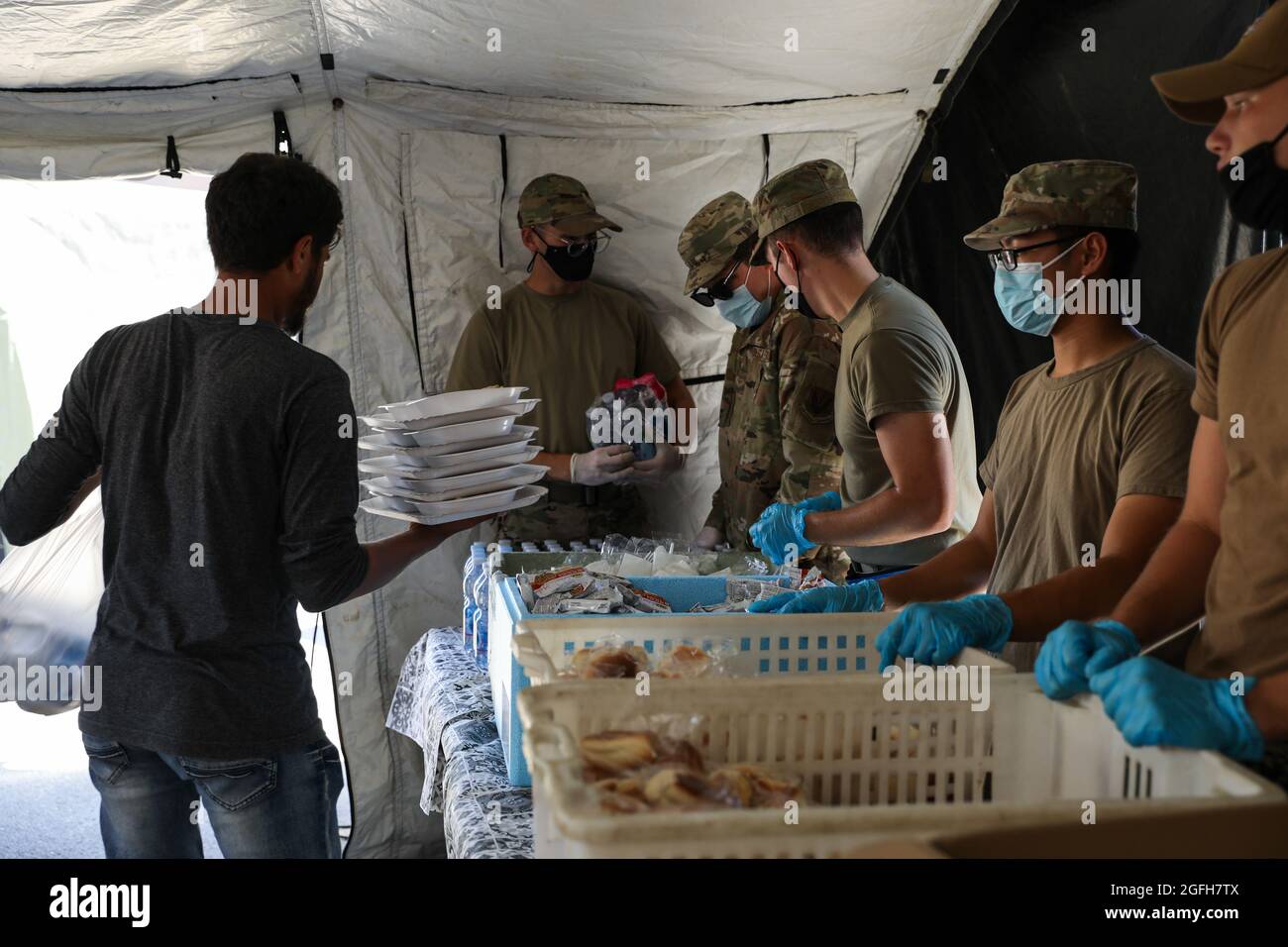 STATION NAVALE AÉRIENNE DE SIGONELLA, Italie (août 24, 2021) les membres du Service servent un déjeuner aux évacués de la base aérienne navale de Sigonella, le 24 août 2021. NAS Sigonella appuie actuellement la mission du ministère de la Défense visant à faciliter le départ et le déplacement en toute sécurité des citoyens américains, des bénéficiaires de visas d'immigration spéciaux et des populations afghanes vulnérables en provenance d'Afghanistan. (É.-U. Photo de la marine par Claire DuBois, spécialiste des communications de masse, 2e classe) Banque D'Images
