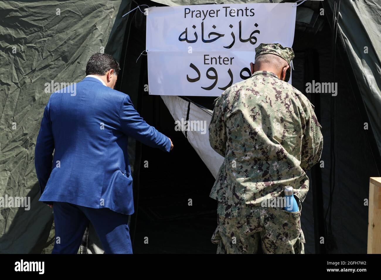 STATION NAVALE AÉRIENNE DE SIGONELLA, Italie (août 24, 2021) Kheit Abdelhafic, un imam de la communauté locale, à gauche, visite une tente de prière mise en place pour les évacués musulmans à la base aérienne navale de Sigonella, le 24 août 2021. NAS Sigonella appuie actuellement la mission du ministère de la Défense visant à faciliter le départ et le déplacement en toute sécurité des citoyens américains, des bénéficiaires de visas d'immigration spéciaux et des populations afghanes vulnérables en provenance d'Afghanistan. (É.-U. Photo de la marine par Claire DuBois, spécialiste des communications de masse, 2e classe) Banque D'Images